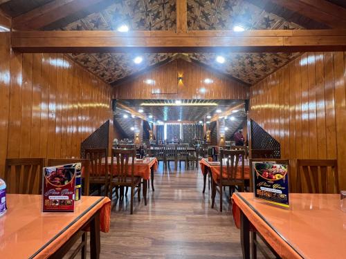 a restaurant with wooden walls and wooden tables and chairs at Pine View Resort in Gulmarg