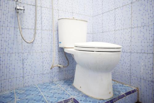 um WC branco numa casa de banho com azulejos azuis em OYO Life 92886 Rumah Nyaman Radhika 2 Syariah em Tuban