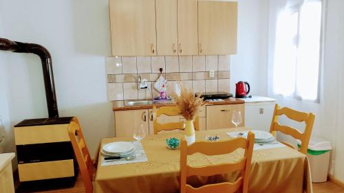 una cocina con mesa, sillas, mesa y silla en Apartman Barbara en Fužine