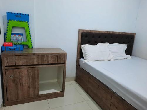 um quarto com uma cama e uma mesa de cabeceira com uma balança verde em OYO Life 92883 Kost Ratana Cengkareng Syariah em Jakarta