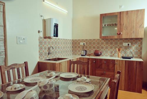 a kitchen with a table with plates and bowls on it at White Serenity Villa Udupi in Udupi