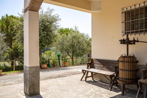 a wooden bench sitting on a patio with a gate at Sole Verde green house in Terricciola