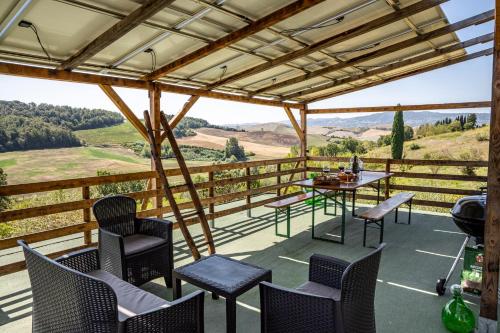 a patio with chairs and a table with a view at Sole Verde green house in Terricciola