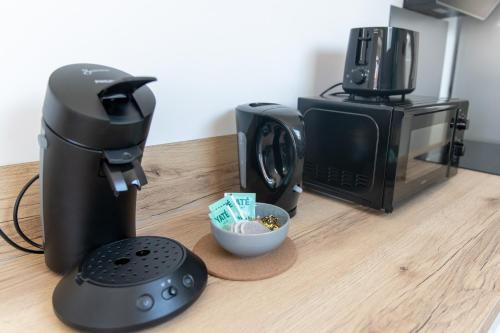 a coffee maker and a microwave on a counter at KASA NOVA - Tout équipé & CLIMATISATION in Saint-Chamond
