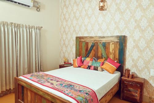 a bedroom with a bed with colorful pillows on it at White Serenity Villa Udupi in Udupi