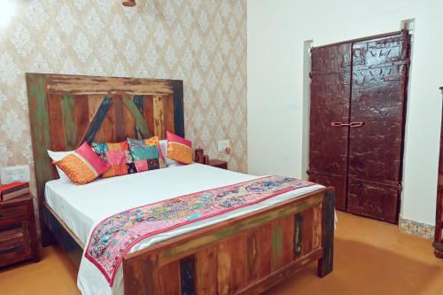 a bedroom with a bed with a wooden headboard and a door at White Serenity Villa Udupi in Udupi
