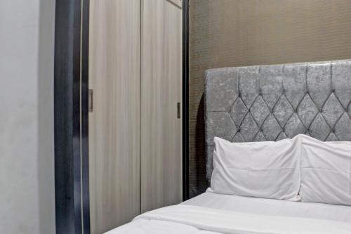 - une chambre avec un lit blanc et une tête de lit en métal dans l'établissement OYO Life 92830 Homestay Slamet Riadi Iv, à Bandar Lampung