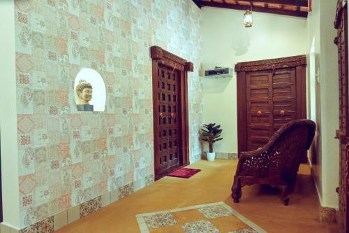 a hallway with a chair in a room with a door at White Serenity Villa Udupi in Udupi