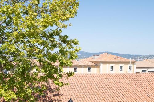 un bâtiment au-dessus d'un toit en carrelage avec un arbre dans l'établissement RIVIERA, à Saint-Tropez