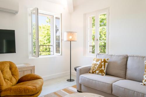 un salon avec un canapé et une chaise dans l'établissement RIVIERA, à Saint-Tropez