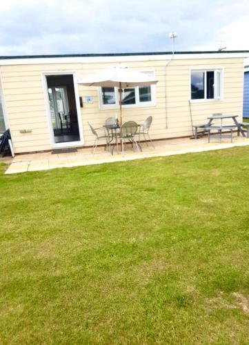 a house with a patio with a table and chairs at Summer Days in Camber
