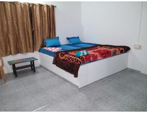 um quarto com uma cama com almofadas azuis em Mayuri Nature Camp, Barangabari, Assam em Jyoti Gaon