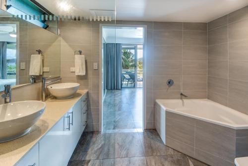 a bathroom with two sinks and a bath tub at POINCIANA 101 HAMILTON ISLAND CENTRALLY LOCATED 3 BEDROOM, plus BUGGY!! in Hamilton Island