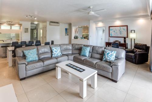 a living room with a couch and a table at POINCIANA 101 HAMILTON ISLAND CENTRALLY LOCATED 3 BEDROOM, plus BUGGY!! in Hamilton Island