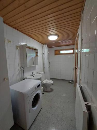y baño con lavadora y aseo. en Kotimaailma - Tilava 2MH asunto saunalla Herttoniemen merellisessä ympäristössä en Helsinki