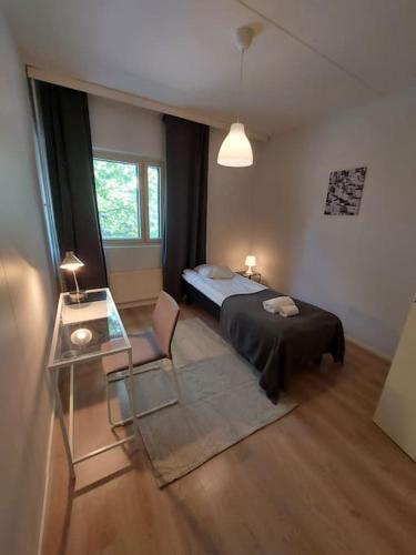 Schlafzimmer mit einem Bett und einem Glastisch in der Unterkunft Kotimaailma - Tilava 2MH asunto saunalla Herttoniemen merellisessä ympäristössä in Helsinki