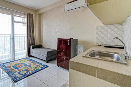 uma cozinha com um lavatório e uma cadeira num quarto em OYO Life 92548 M-square Apartment By Lins Pro em Bandung