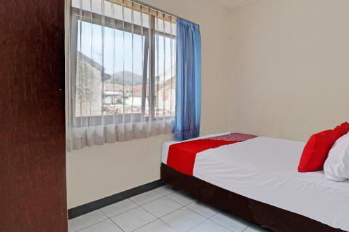 1 dormitorio con cama y ventana grande en OYO Life 92685 Kost Arimbi, en Bandung