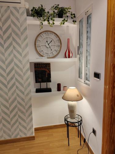 a room with a clock and a table and a lamp at Urbanlux Hospital II in Albacete