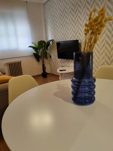 a vase sitting on a white table with flowers in it at Urbanlux Hospital II in Albacete