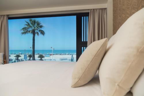 a bedroom with a bed with a view of the ocean at Apartamentos Playa Victoria in Cádiz