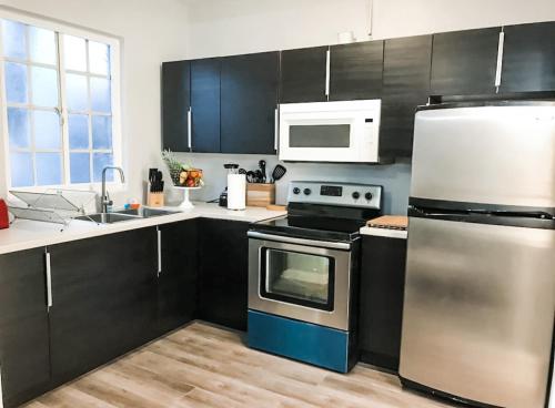 a kitchen with stainless steel appliances and black cabinets at 2bdrm Gaslamp Conv Cntr - W Parking & 4 Beds #1 in San Diego