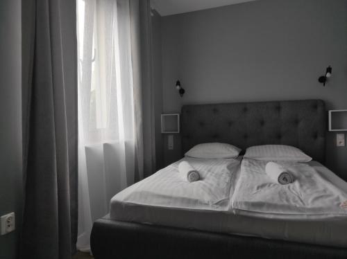 łóżko z białą pościelą i poduszkami w sypialni w obiekcie Apartament Homole E1 z ogródkiem w mieście Szczawnica