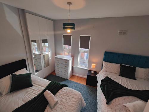 a bedroom with two beds and a dresser at Modern 4 Bedroom Townhouse in City Centre in Dublin