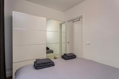 a white bedroom with two towels on a bed at Kerkakker0 Luxery apartment with garden in the city center in Eindhoven