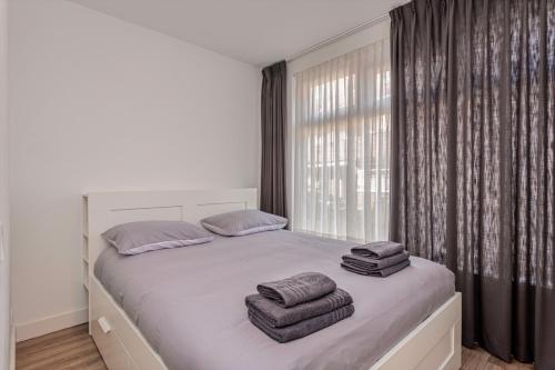 a bedroom with a large bed with towels on it at Kerkakker0 Luxery apartment with garden in the city center in Eindhoven