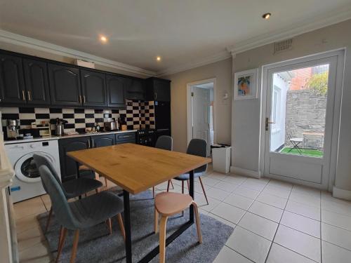 a kitchen with a wooden table and chairs at Modern 4 Bedroom Townhouse in City Centre in Dublin