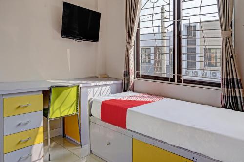 a bedroom with a bed and a desk and a window at OYO Life 92614 Rukost E-3 Colombus in Karawang