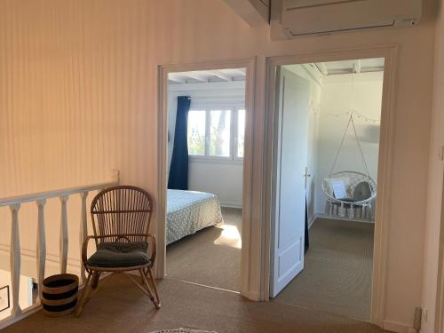a bedroom with a bed and a chair next to a door at La Sauveterre in Mours-Saint-EusÃ¨be
