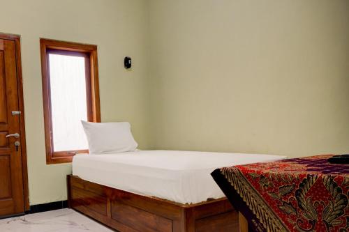 A bed or beds in a room at OYO Life 92922 Kost Bu Mala 1 Syariah