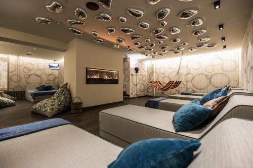a room with three beds and a ceiling with shoes at THOMSN Central Hotel & Appartements in Saalbach Hinterglemm