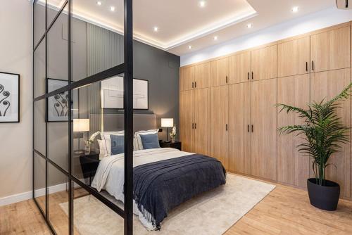 1 dormitorio con 1 cama grande y armarios de madera en Exyca Embajadores, en Madrid