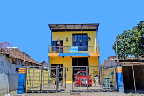 a yellow house with a gate in front of it at OYO Life 92915 Duta Amnan Syariah in Sidoarjo