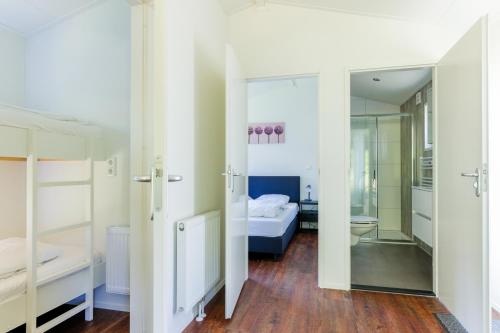 a bedroom with a bed and a mirror at Recreatiepark de Voorst in Kraggenburg