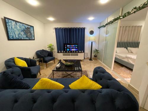 a living room with a blue couch and yellow pillows at Apartment in Islamabad F-10 in Islamabad