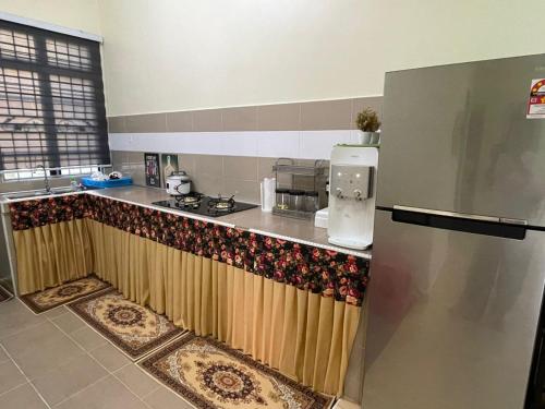 uma cozinha com uma bancada e um frigorífico em AR HOMESTAY KUALA TERENGGANU em Kuala Terengganu