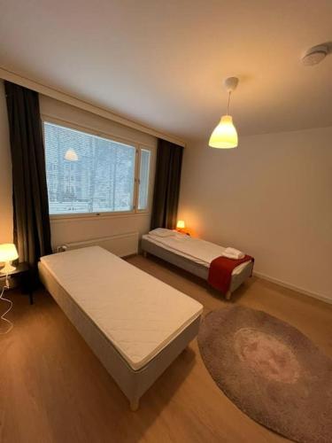 1 dormitorio con 2 camas y ventana en Kotimaailma - Kotoisa 3MH asunto Kontulassa, en Helsinki