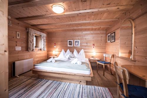 una camera con un letto in una cabina di legno di Alpenzauber / Chalet AlmZeit / Almhütte Zillertal a Schwaz