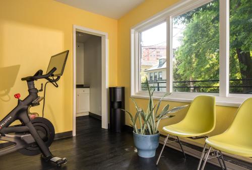 a room with a treadmill and chairs and a window at Park Lane Suites & Inn in Portland