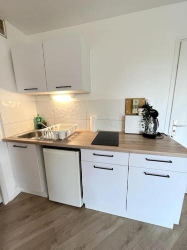 une cuisine avec des armoires blanches et un comptoir en bois dans l'établissement The Jungle Studio, loggia & parking dans résidence, à Romans-sur-Isère