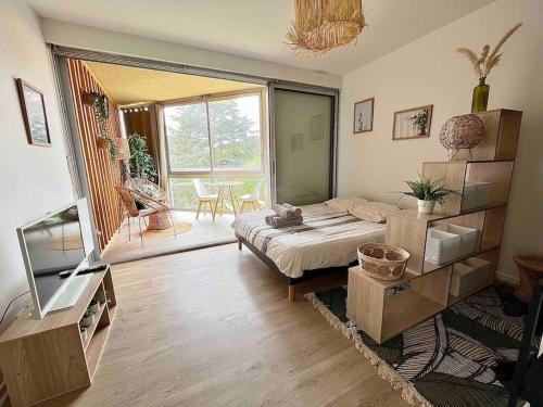 1 dormitorio con cama y vistas a un patio en The Jungle Studio, loggia & parking dans résidence, en Romans-sur-Isère