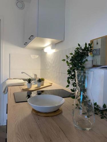 un comptoir en bois avec un bol et un vase en verre dans l'établissement The Jungle Studio, loggia & parking dans résidence, à Romans-sur-Isère