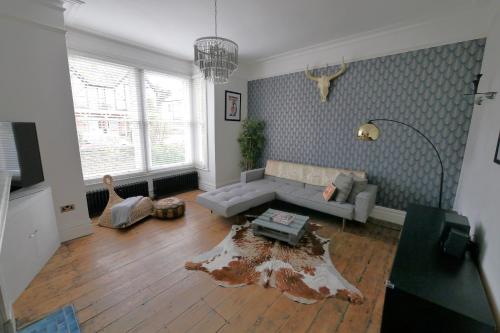 a living room with a couch and a table at Quirky spacious ground floor Victorian garden flat in Worthing