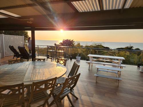 un patio con mesa, sillas y el océano en Oceanview Manor by "Peppy Beach Retreats" - Two Houses in One with Panoramic Views, en Capel