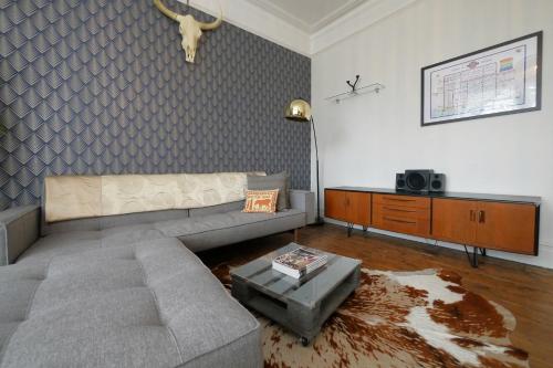 a living room with a couch and a table at Quirky spacious ground floor Victorian garden flat in Worthing