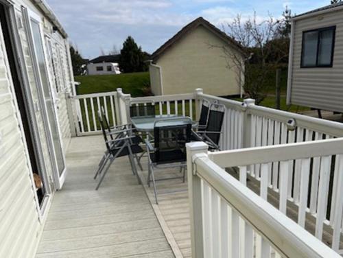 a deck with a table and chairs on a house at 3 Bed 2 Bath Static Mobile Home On Fantastic Park in Mablethorpe